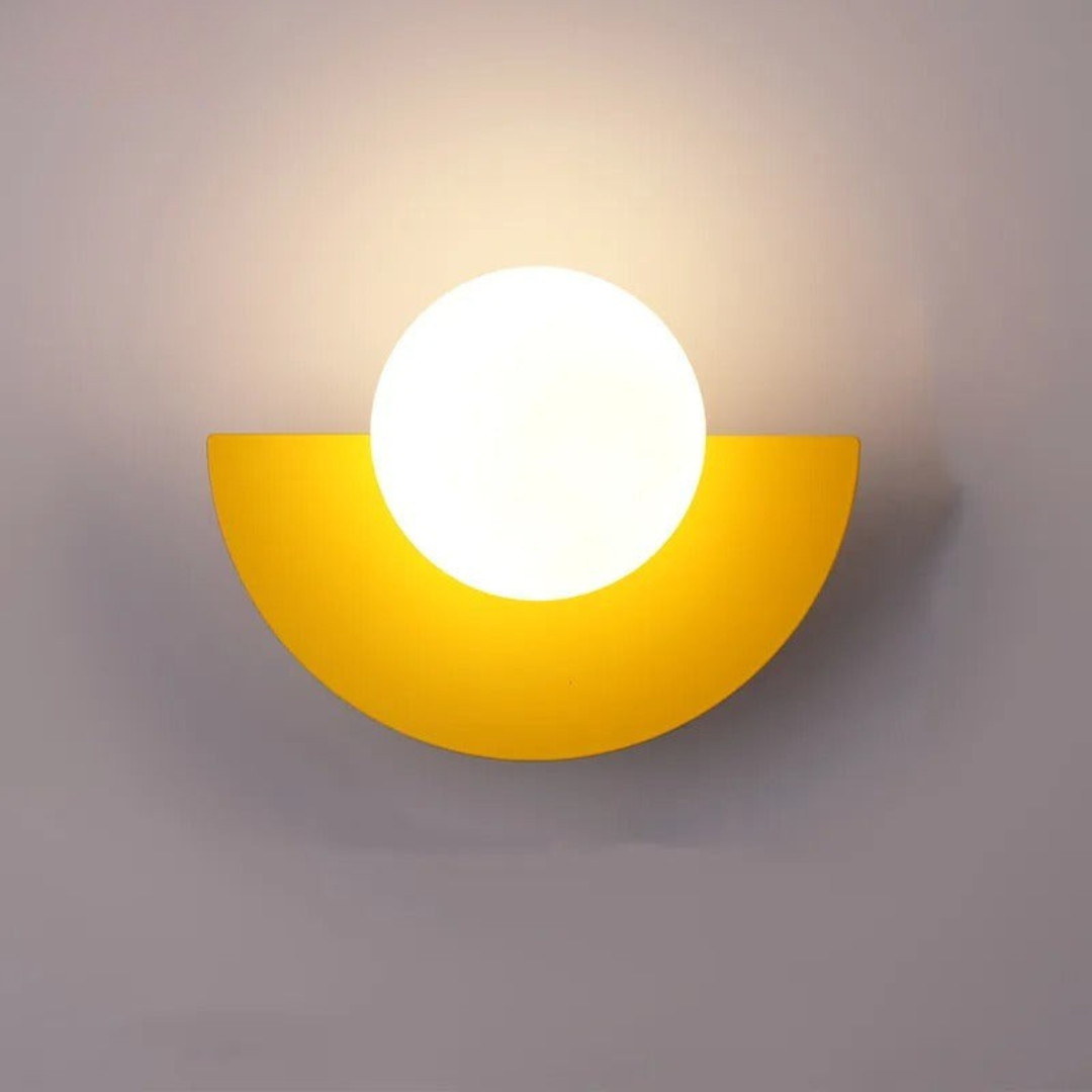 Yellow wall sconce with a white light bulb on a gray background