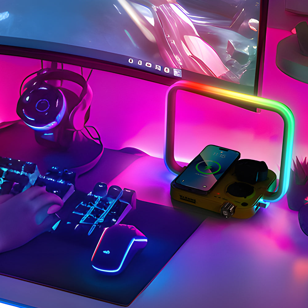 Neon-lit gaming setup with computer monitor, keyboard, mouse, and smartphone on a desk.