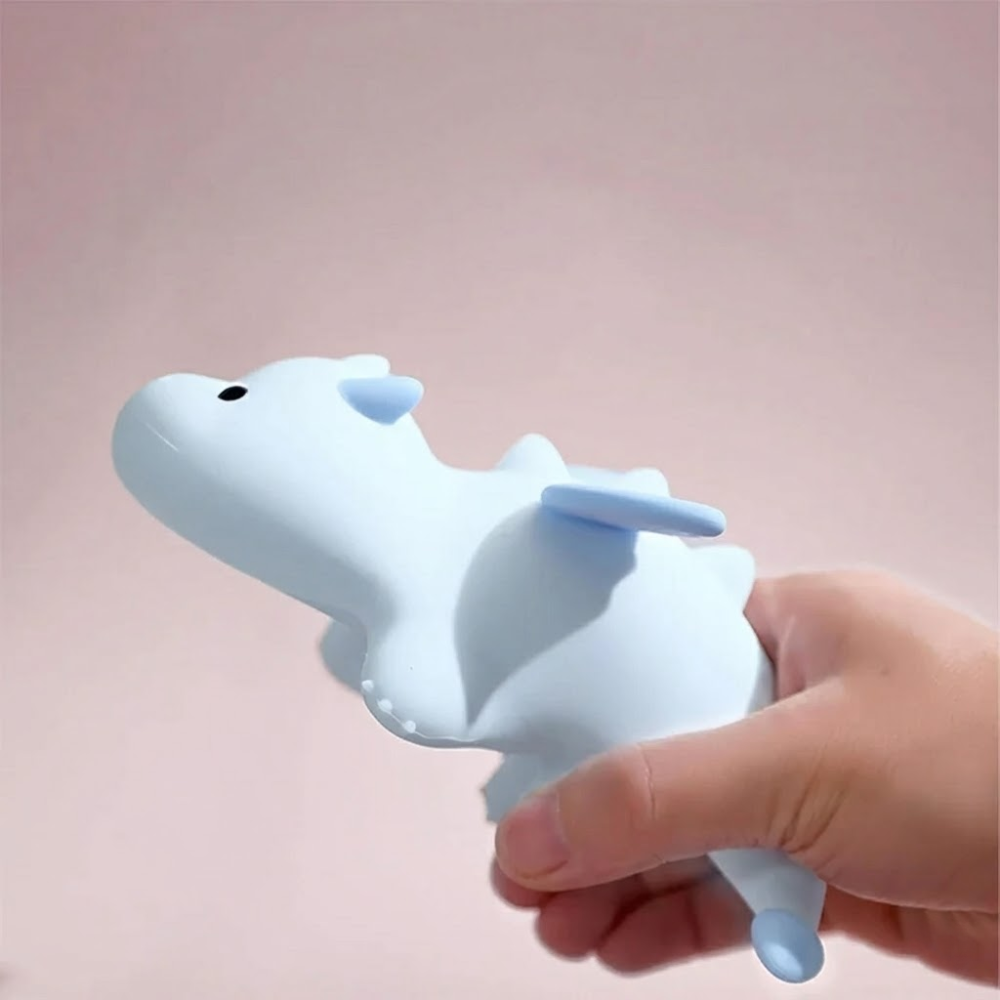 Hand holding a white and blue unicorn-shaped object against a pink background