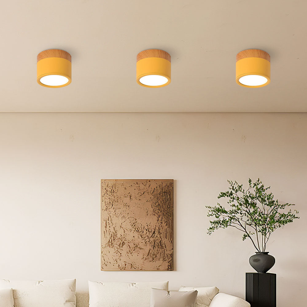 Three ceiling lights with yellow shades in a living room setting.