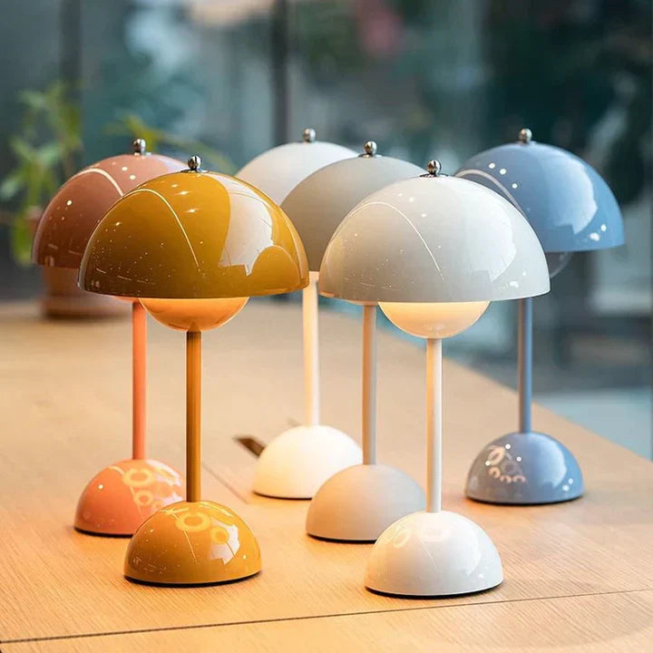 Set of colorful mini table lamps on a wooden surface with a blurred background