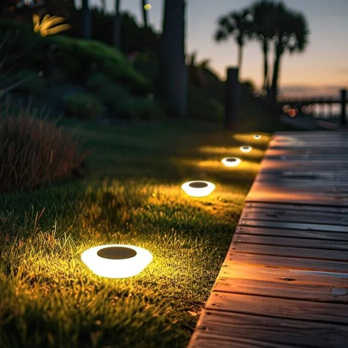 Solar-powered garden lights illuminating a wooden pathway at dusk.