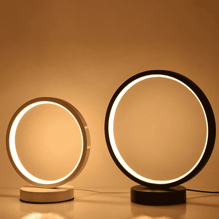 Two circular table lamps with illuminated rings on a warm beige background