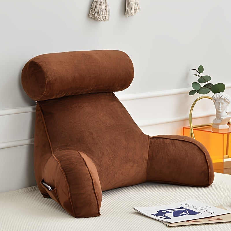 Brown backrest pillow on a white floor with a white wall and decorative items in the background.