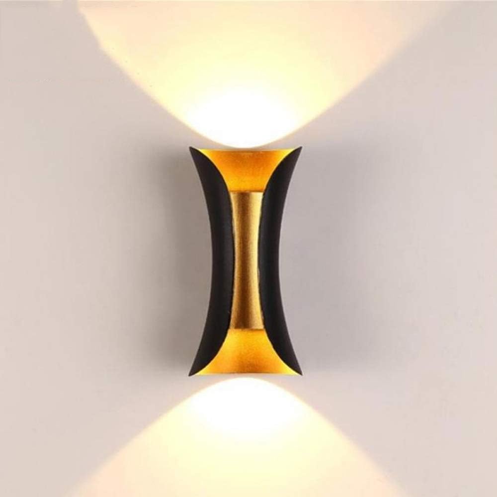 Modern wall light fixture with gold and black design on a neutral background