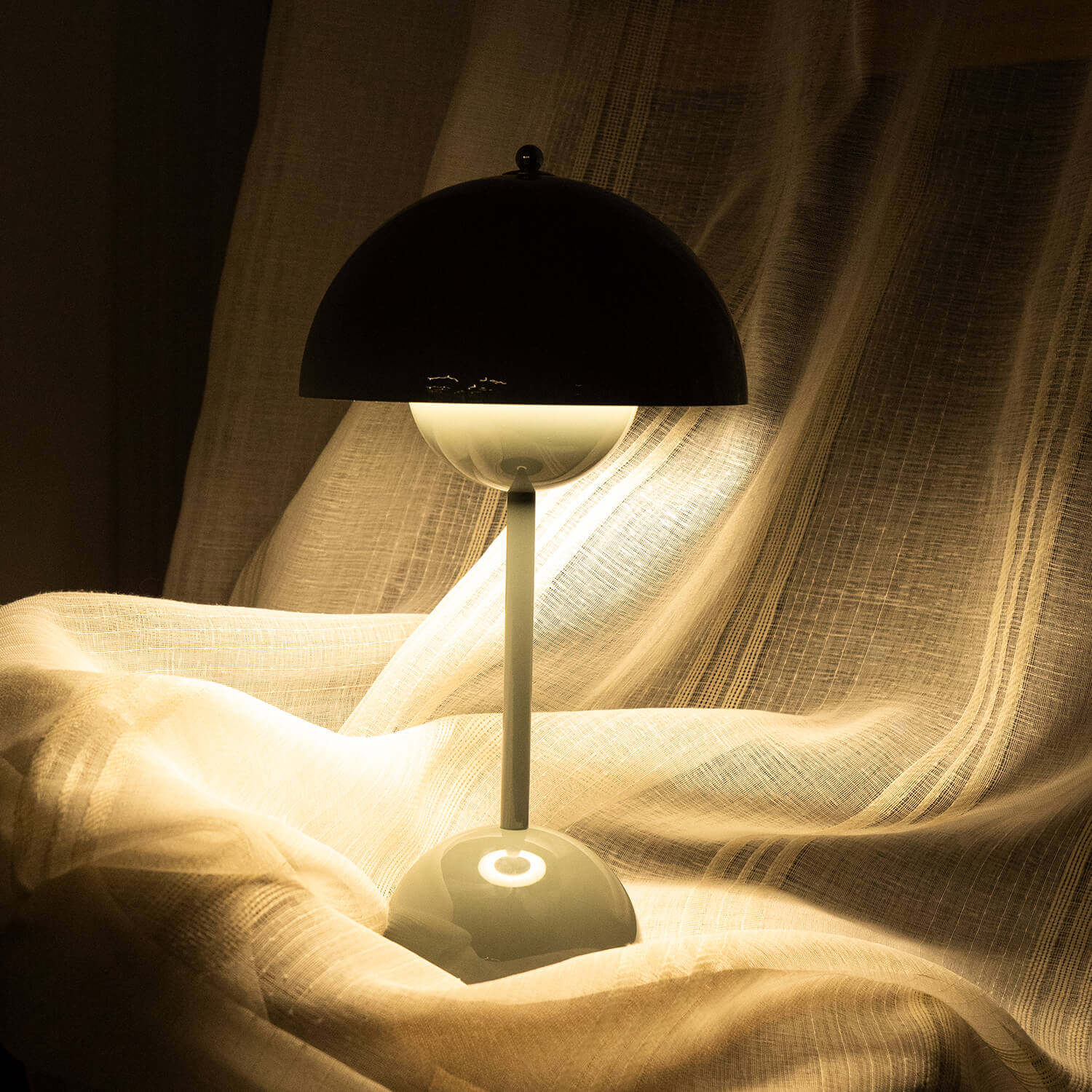 Black lamp with a white shade on a fabric background