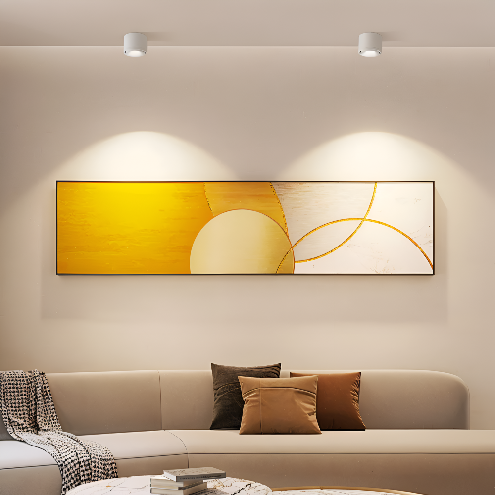 Modern living room with a beige sofa, abstract yellow painting, and decorative pillows.