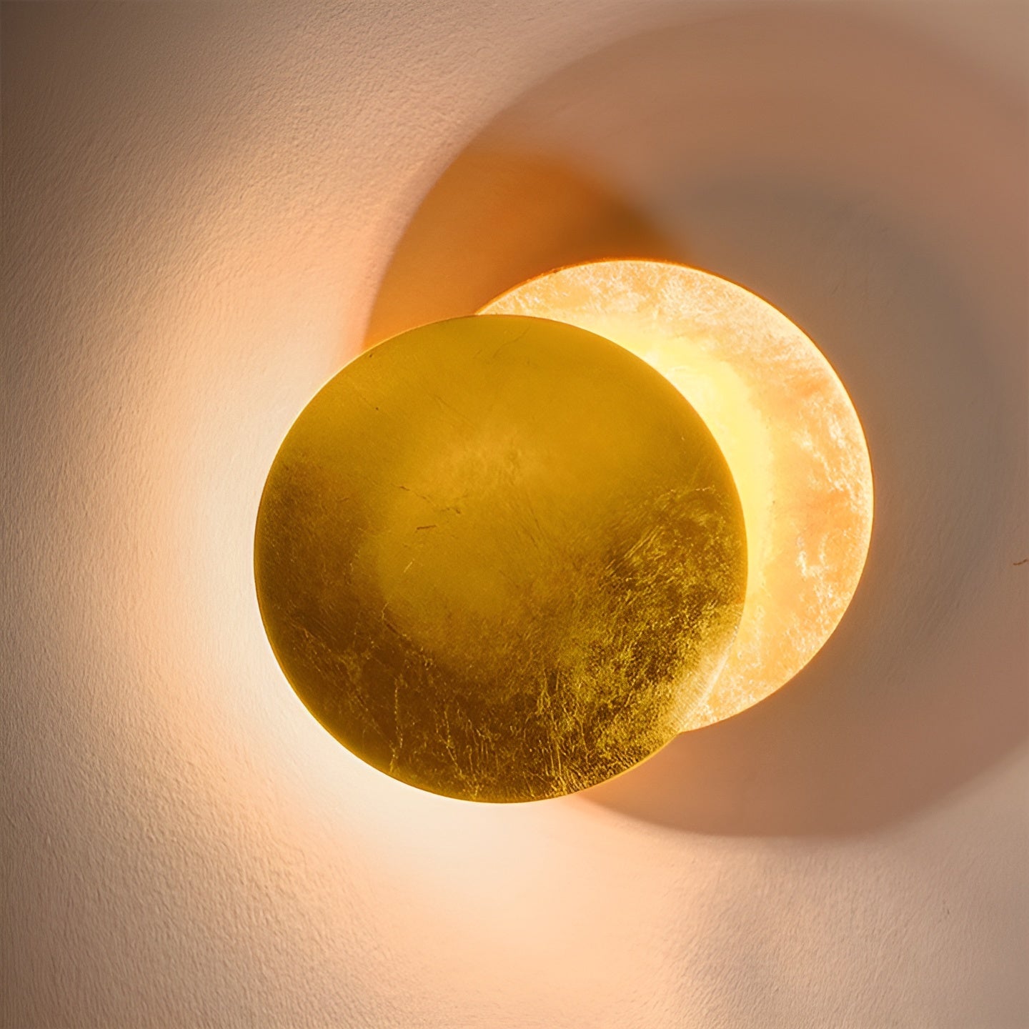 Round wall light fixture casting a warm glow on a textured wall.