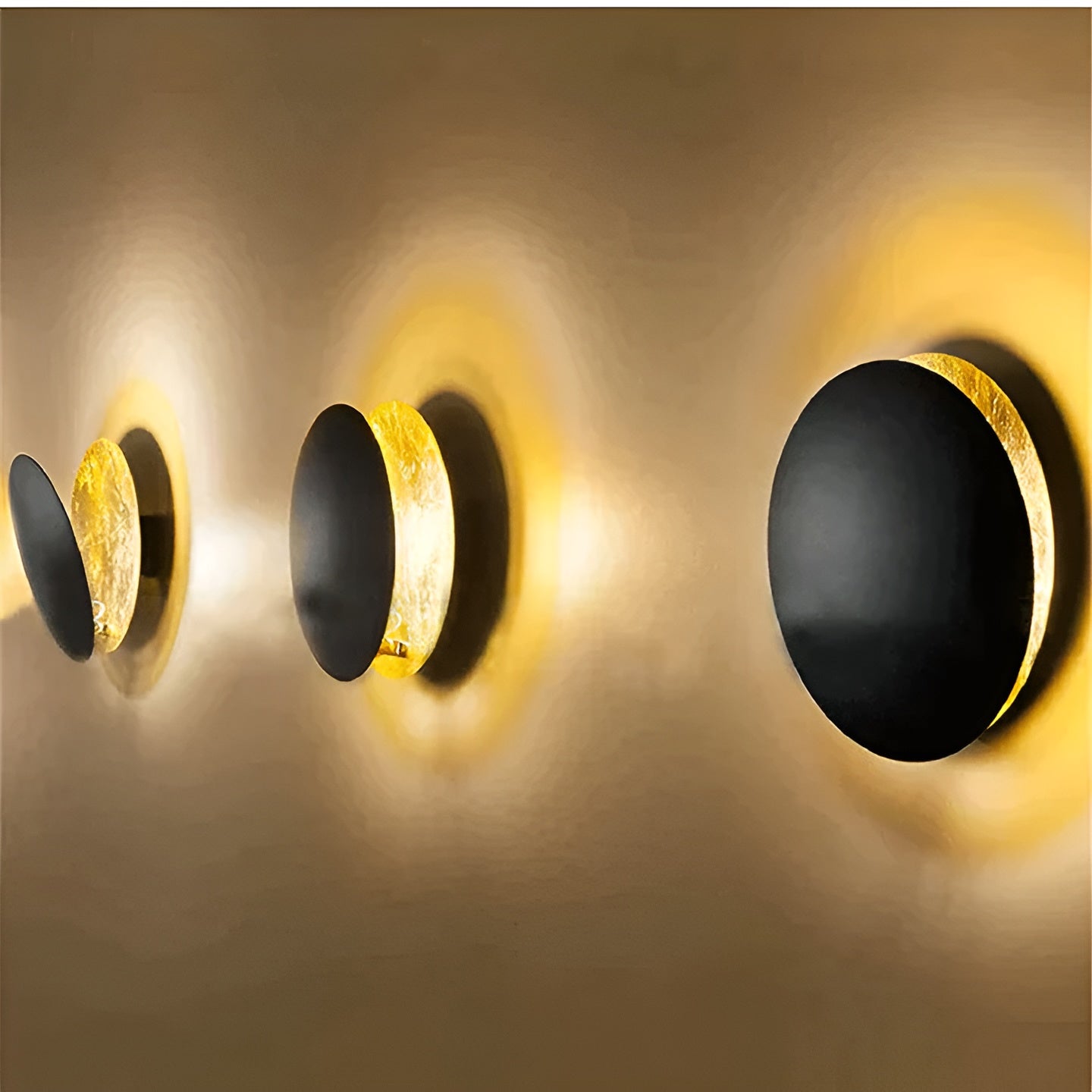 Modern wall lights with black and gold design on a neutral background
