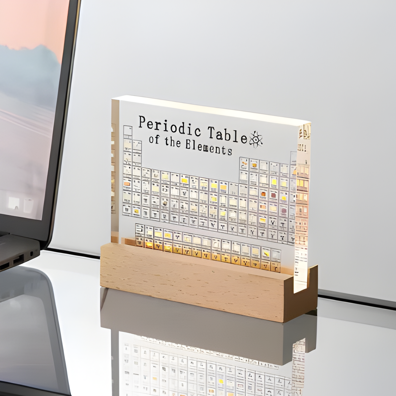 Light-up periodic table of elements on a desk with a laptop in the background