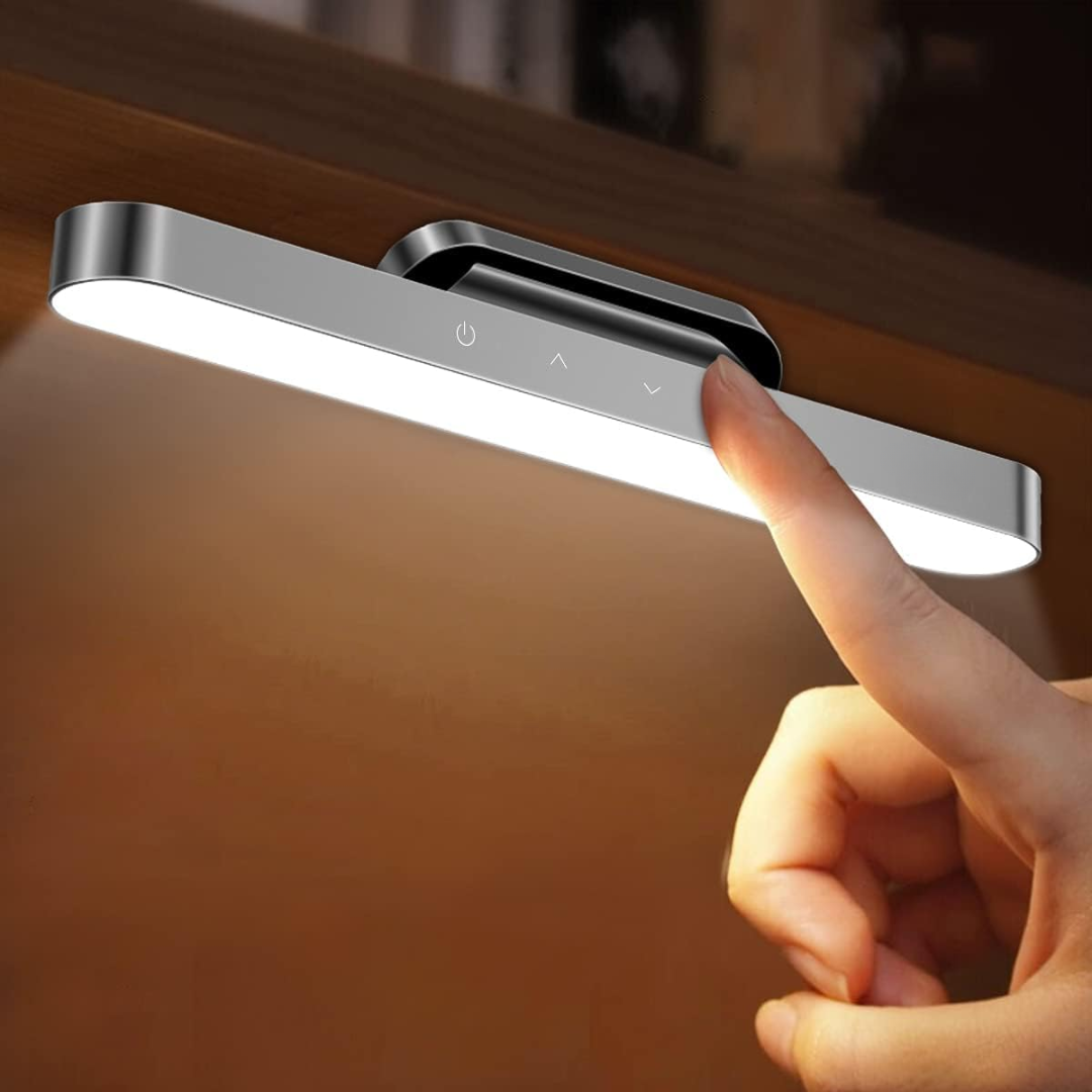 Hand holding a touch-sensitive LED light on a wooden surface