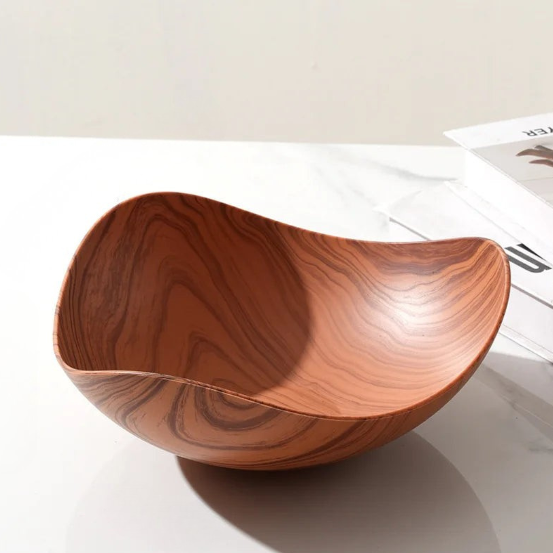 Wooden bowl with a wavy design on a white surface