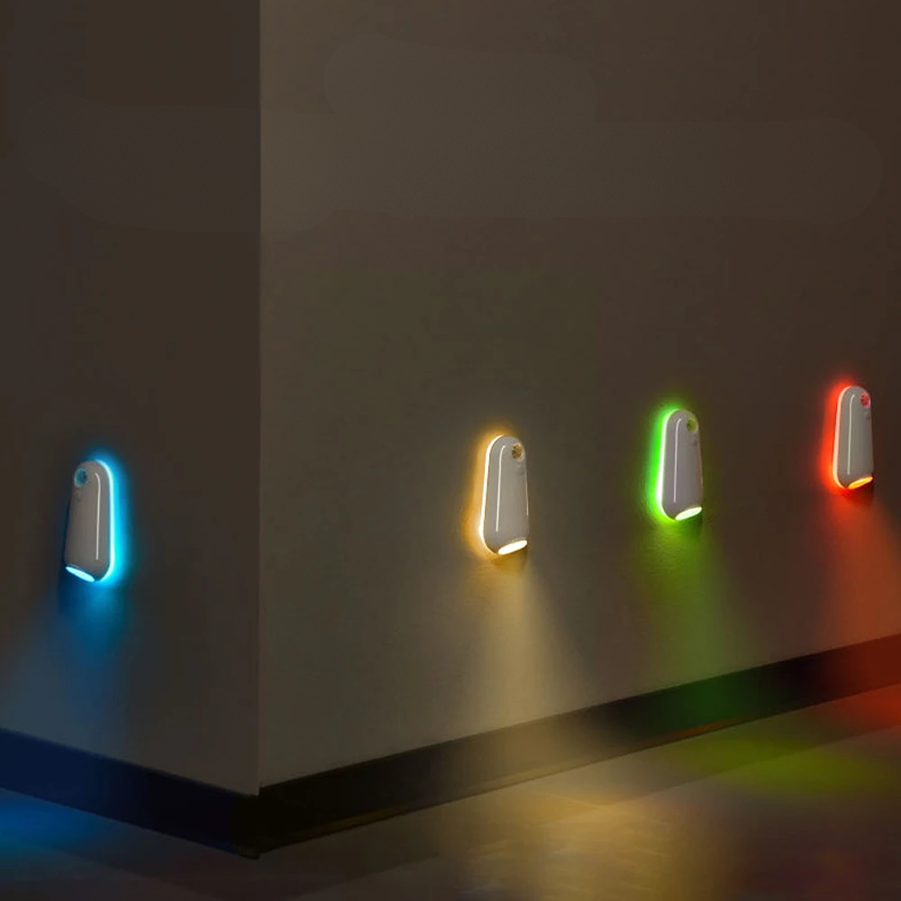 Four wall-mounted light fixtures emitting colorful lights on a dark wall.