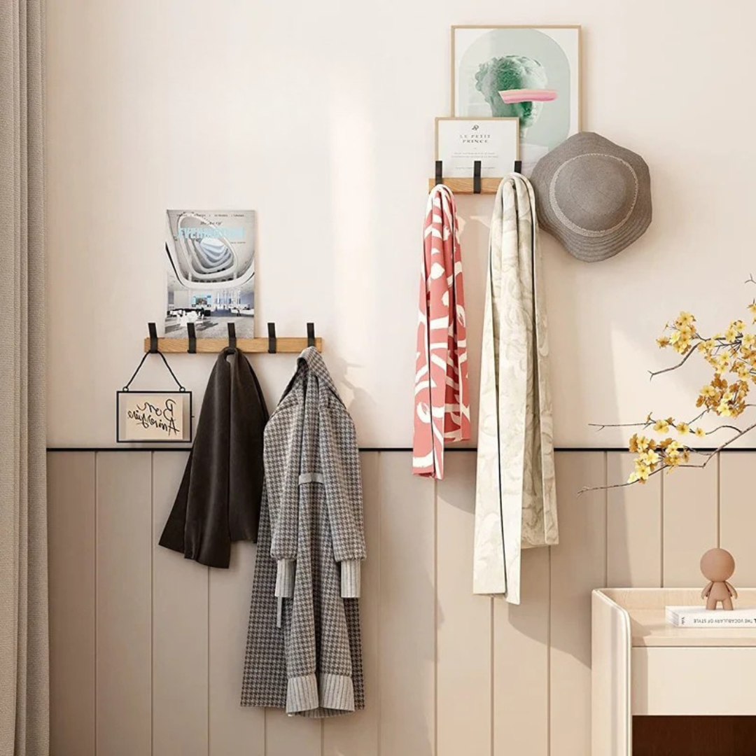 Wall-mounted coat rack with clothes and a hat in a room setting