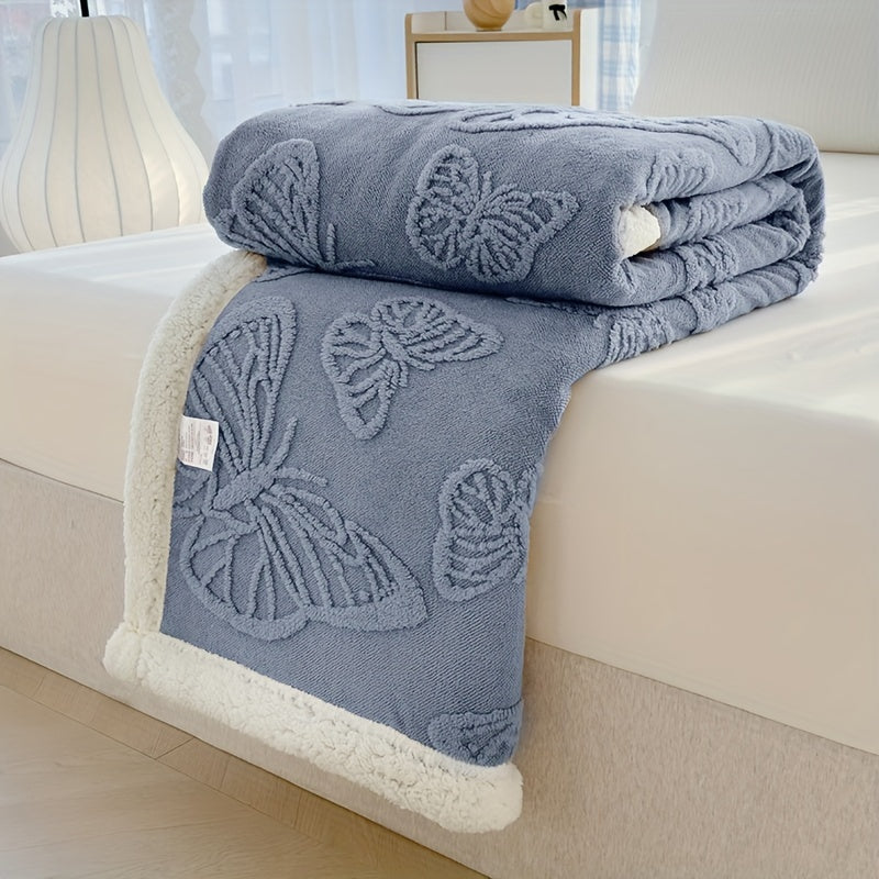 Blue butterfly-patterned blanket on a bed with a white background