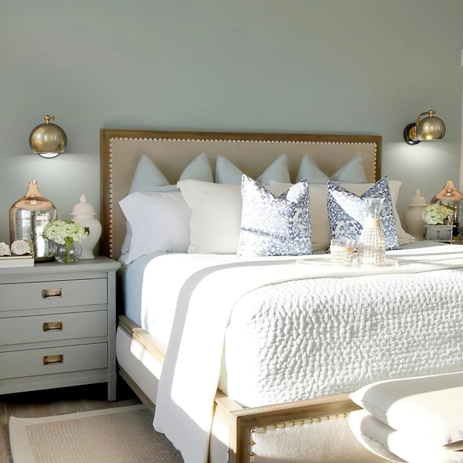 Neatly made bed with decorative pillows in a bedroom setting.