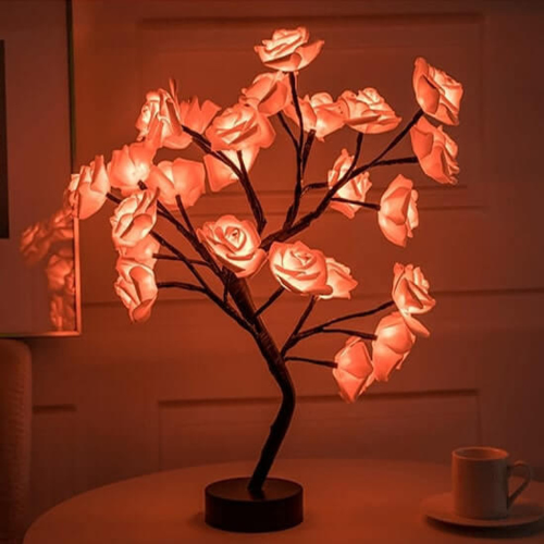 Decorative LED lamp shaped like a rose bush on a table with a cup in the background.