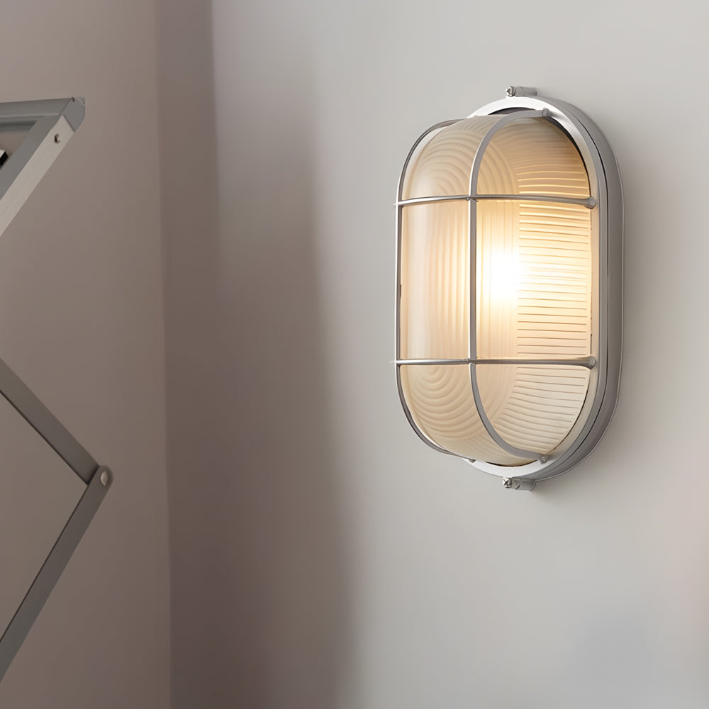Wall-mounted light fixture with glass shade on a neutral wall