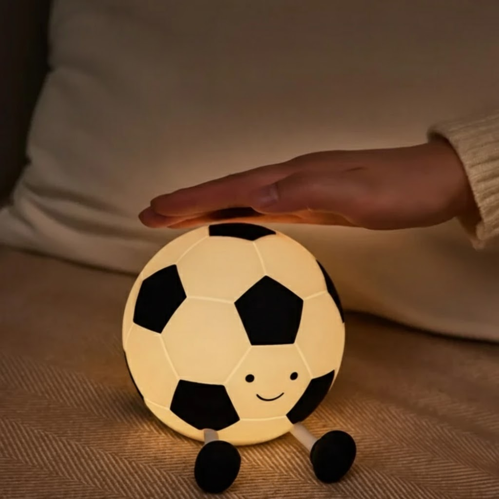 Soccer ball-shaped night light held by a person in a warm setting