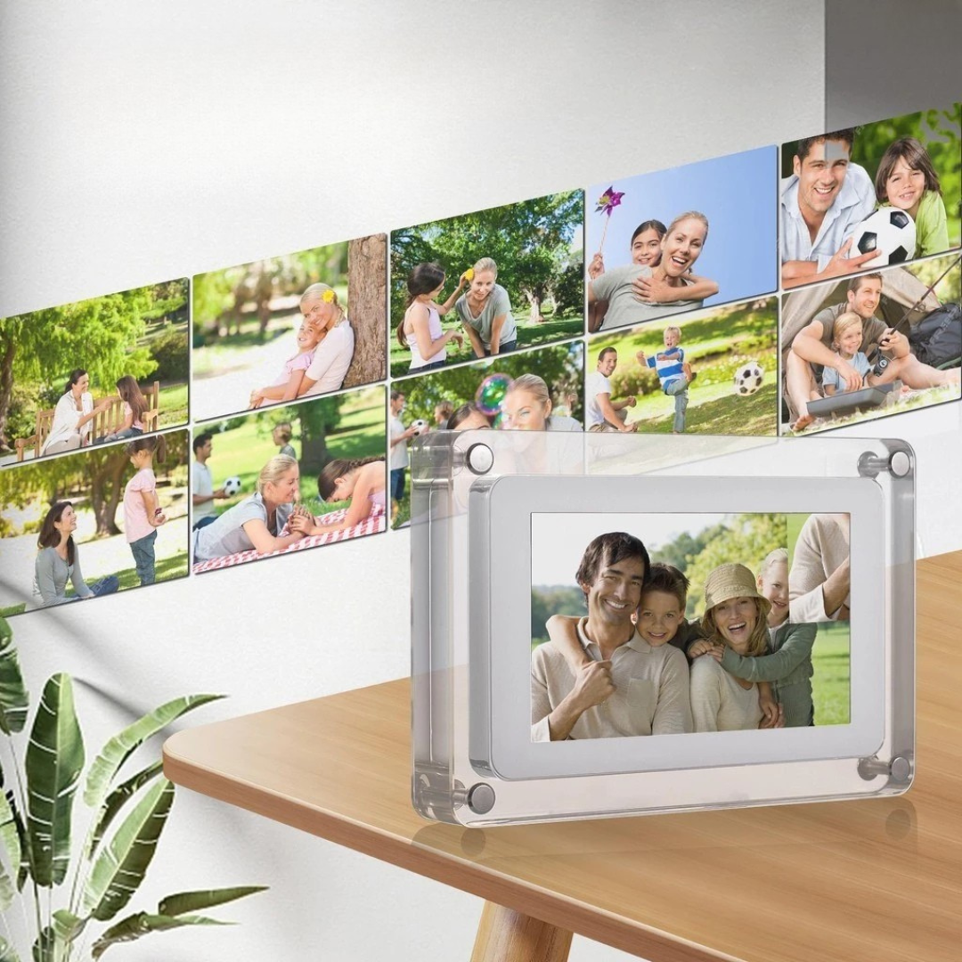 Digital photo frame on a wooden table with a collage of family photos in the background.