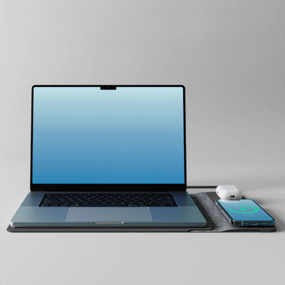 Laptop with a blue screen, mouse, and smartphone on a gray surface