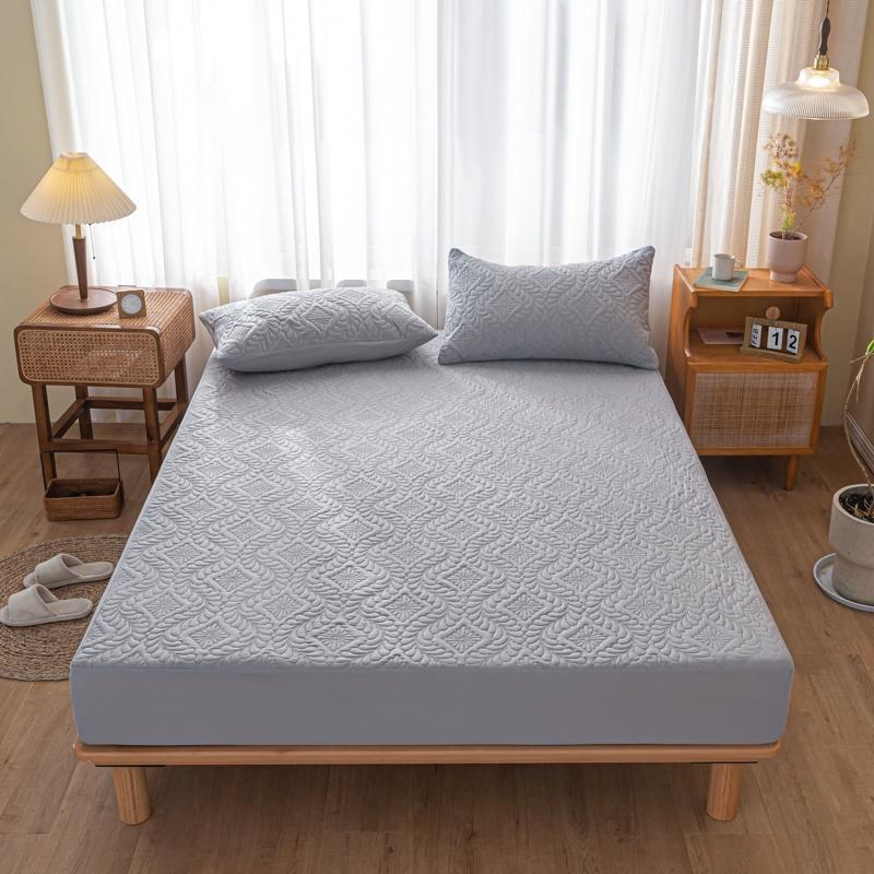 Gray mattress cover on a bed in a bedroom with wooden furniture and curtains.