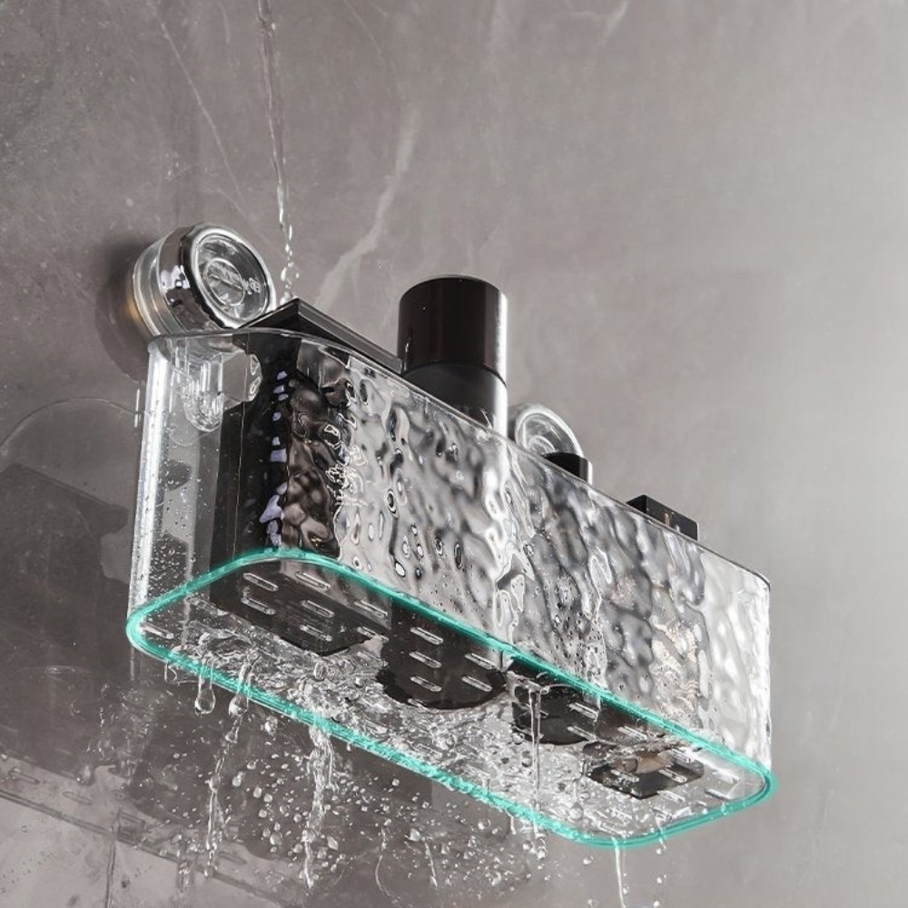 Glass shower shelf with water droplets on a gray wall