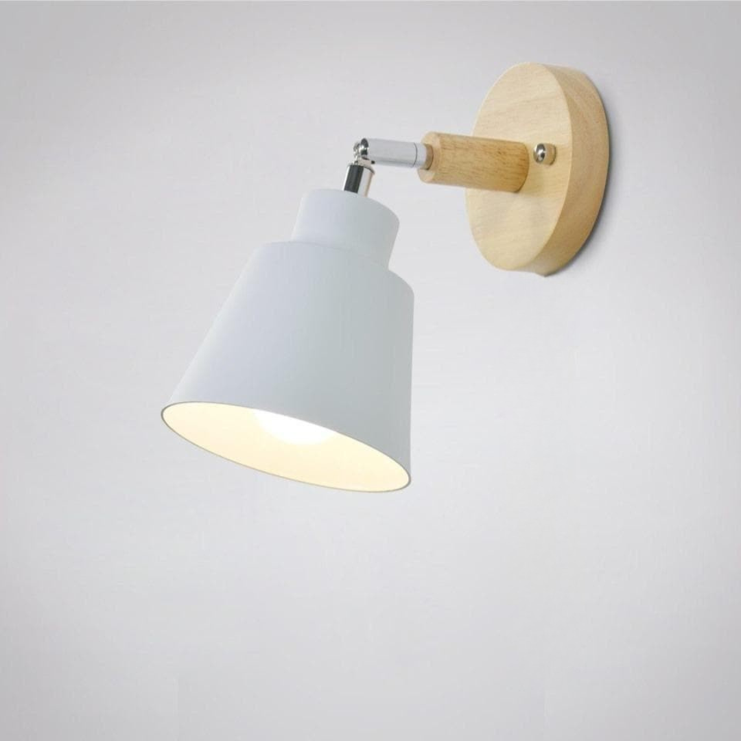 Wall-mounted light fixture with white shade and wooden base on a plain background