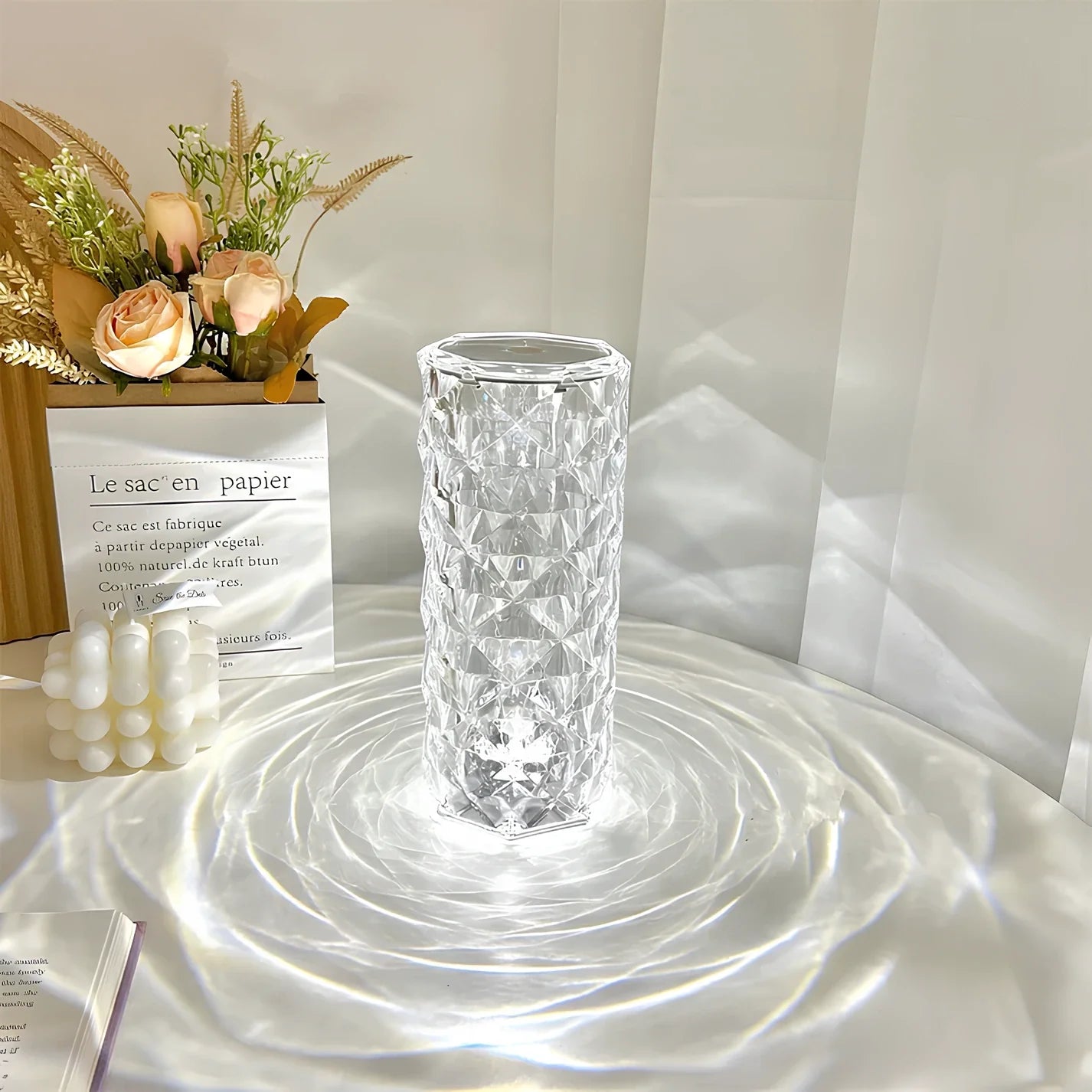 Clear glass vase on a reflective surface with a light background