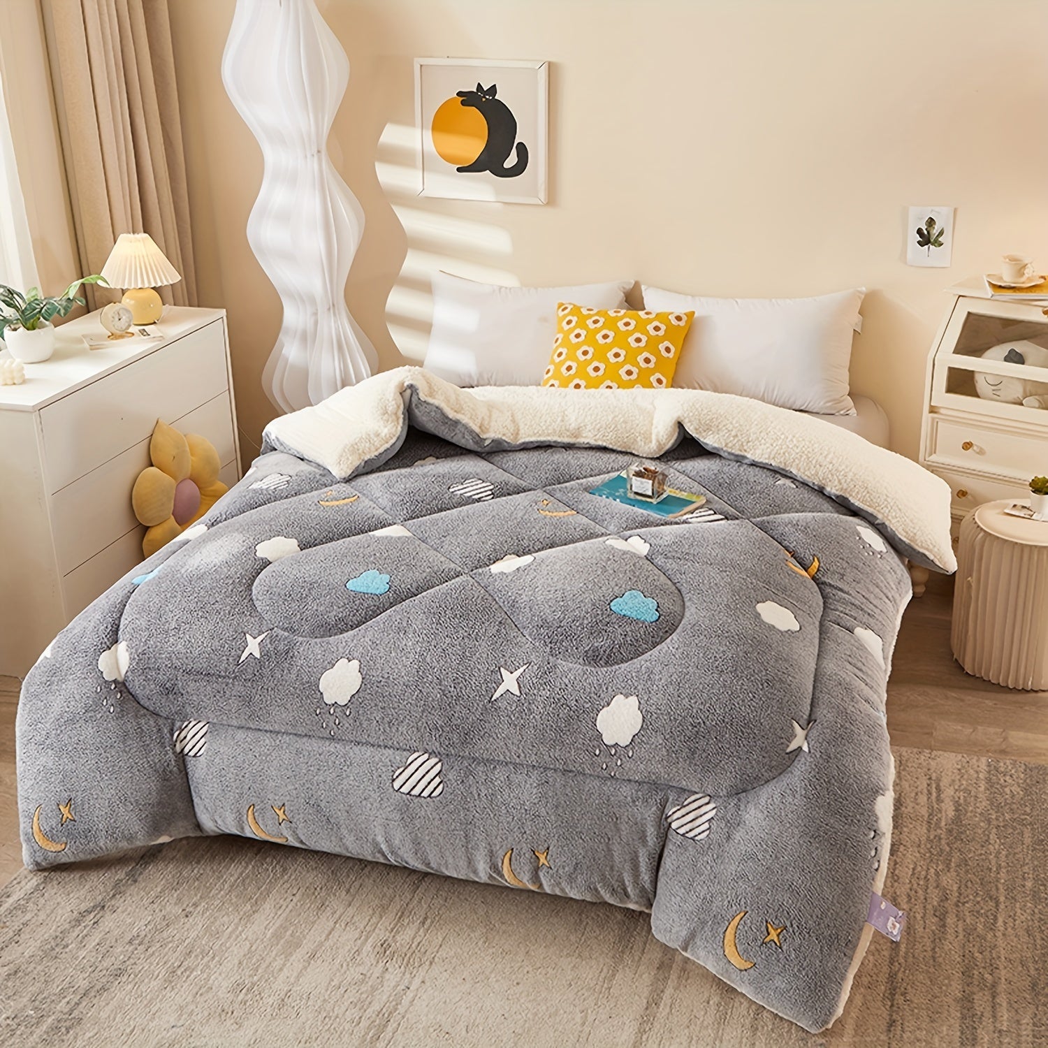 Gray comforter with celestial designs on a bed in a bedroom setting.