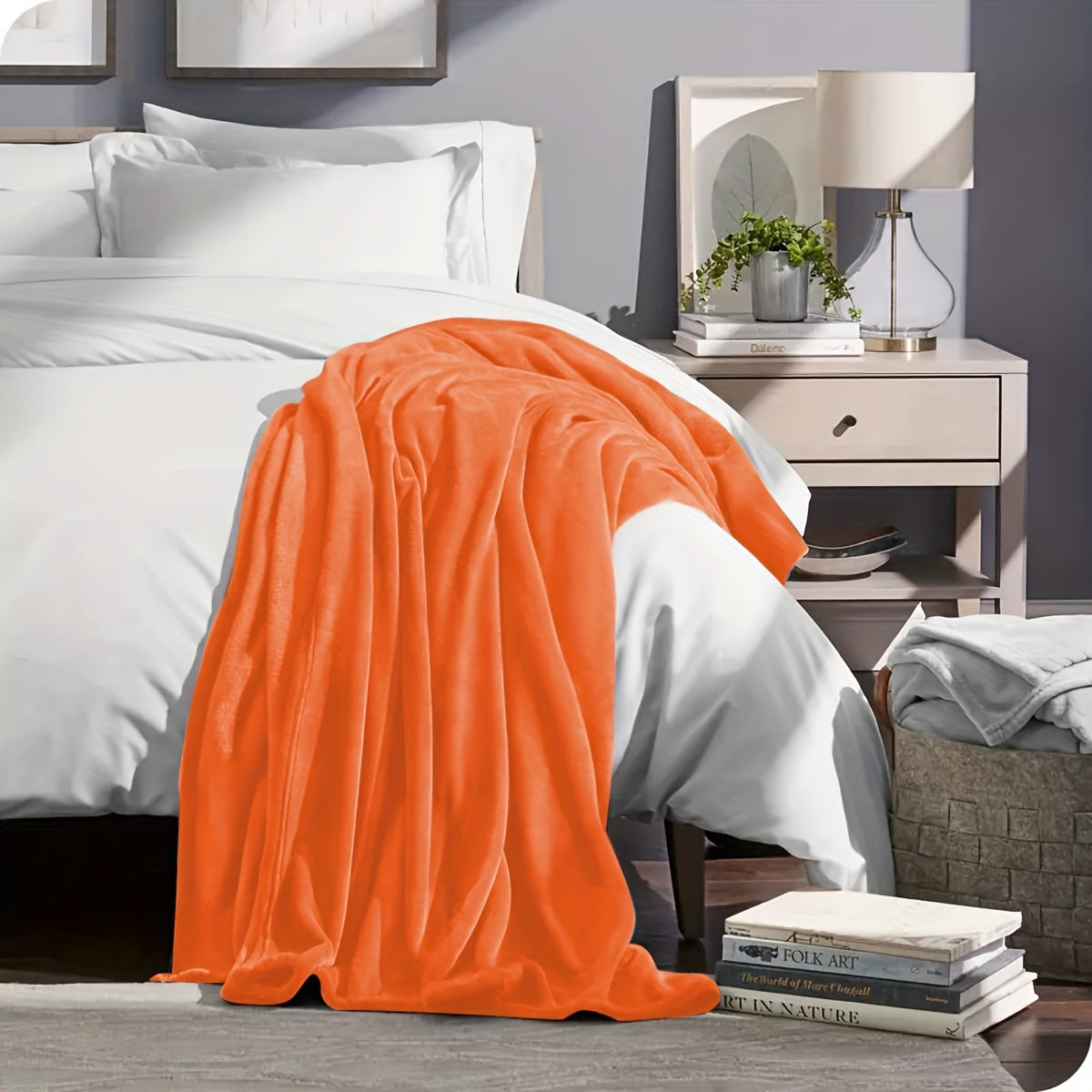 Orange blanket draped over a bed in a bedroom setting with a nightstand and lamp.