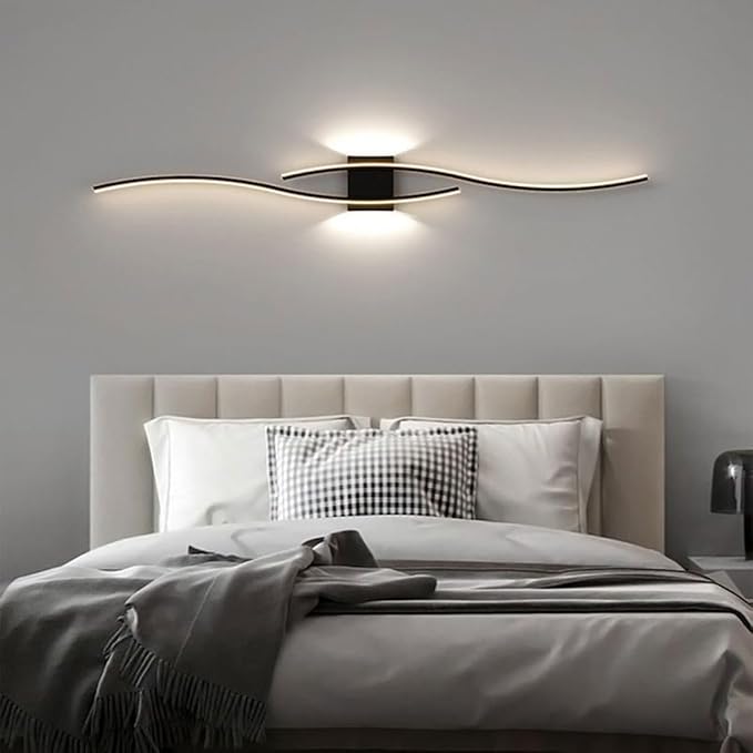 Modern wall light fixture above a bed in a bedroom setting
