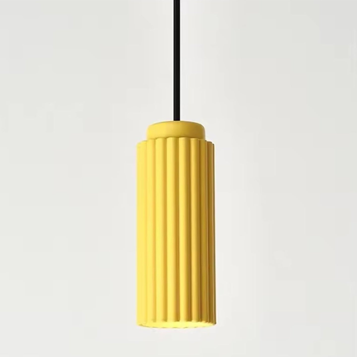 Yellow pendant light with a ribbed design on a white background