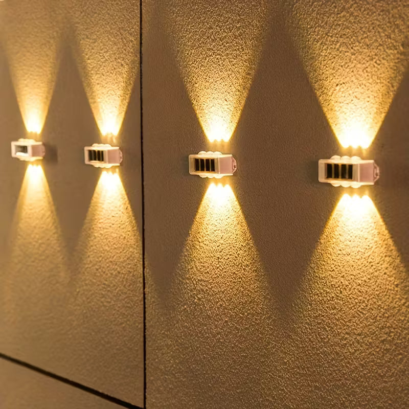 Two wall-mounted lights on a textured wall casting warm light.