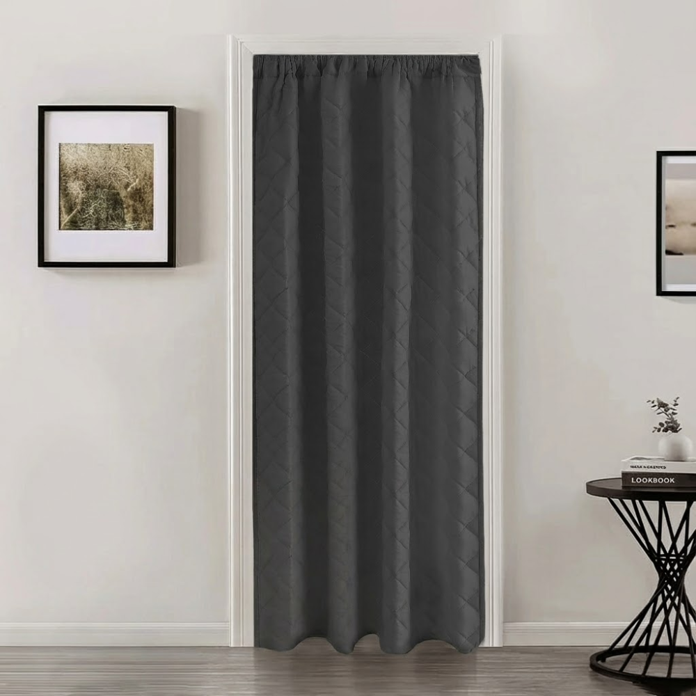 Dark gray curtain on a door with framed pictures on the wall.