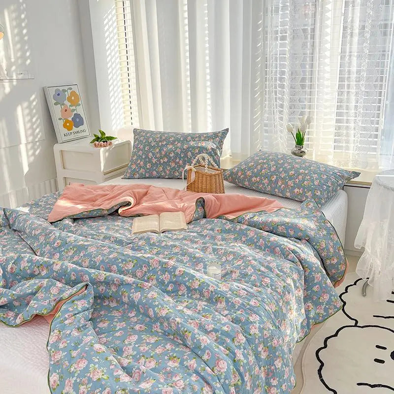 Floral bedding set on a bed with pink pillows and a basket in a bright room.