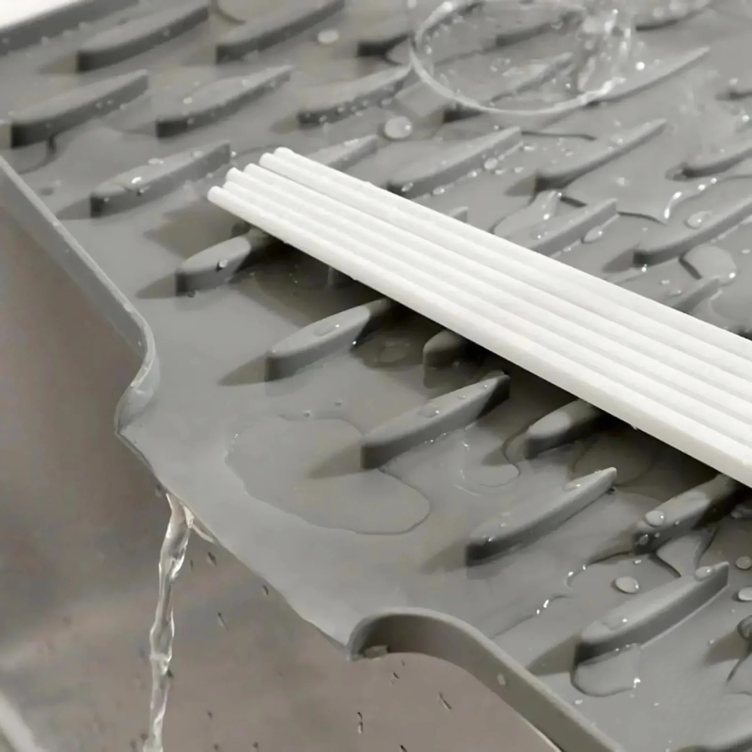 Gray drain cover with white plastic strips on a wet surface