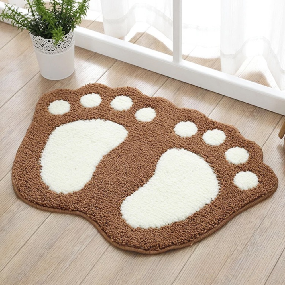 Brown and white foot-shaped rug on a wooden floor with a plant in the background