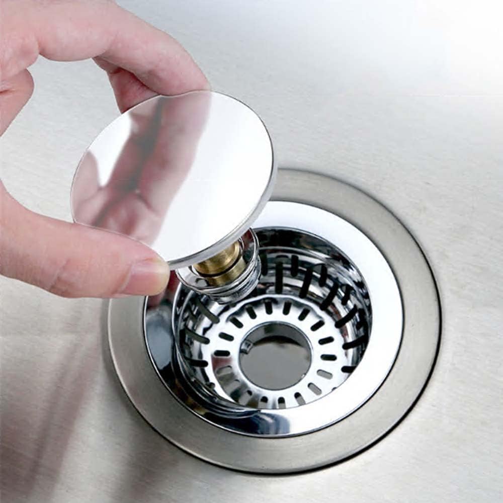Hand replacing a sink drain cover with a metallic drain cover on a silver sink.