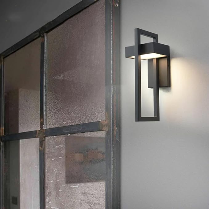 Modern outdoor wall light fixture on a gray wall next to a glass door.