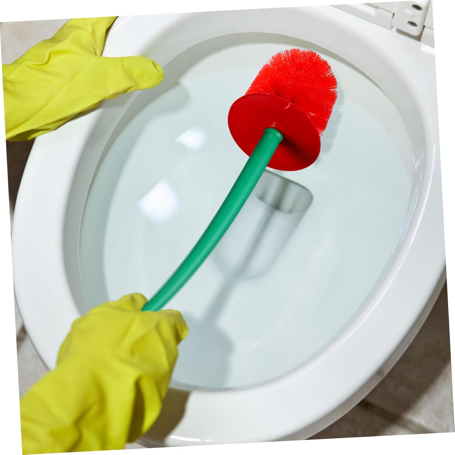 Person cleaning a toilet with a red brush and yellow gloves