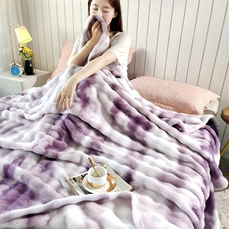Person wrapped in a purple and white blanket in a cozy room.