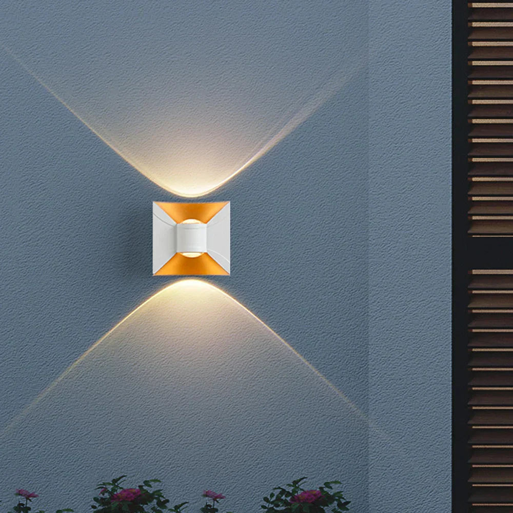 Wall-mounted light fixture on a blue wall with a warm glow