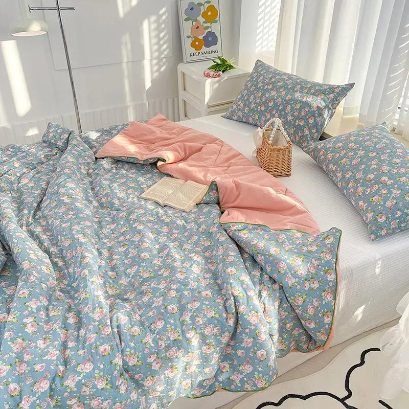 Floral bedding set on a bed with a basket and towel in a bright room.