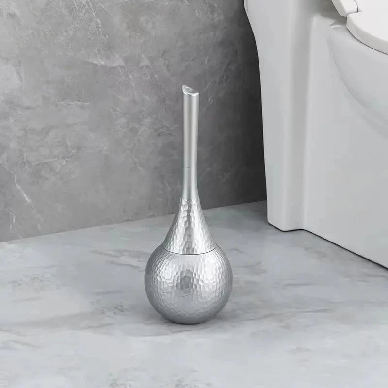 Silver decorative vase on a marble floor with a neutral wall background