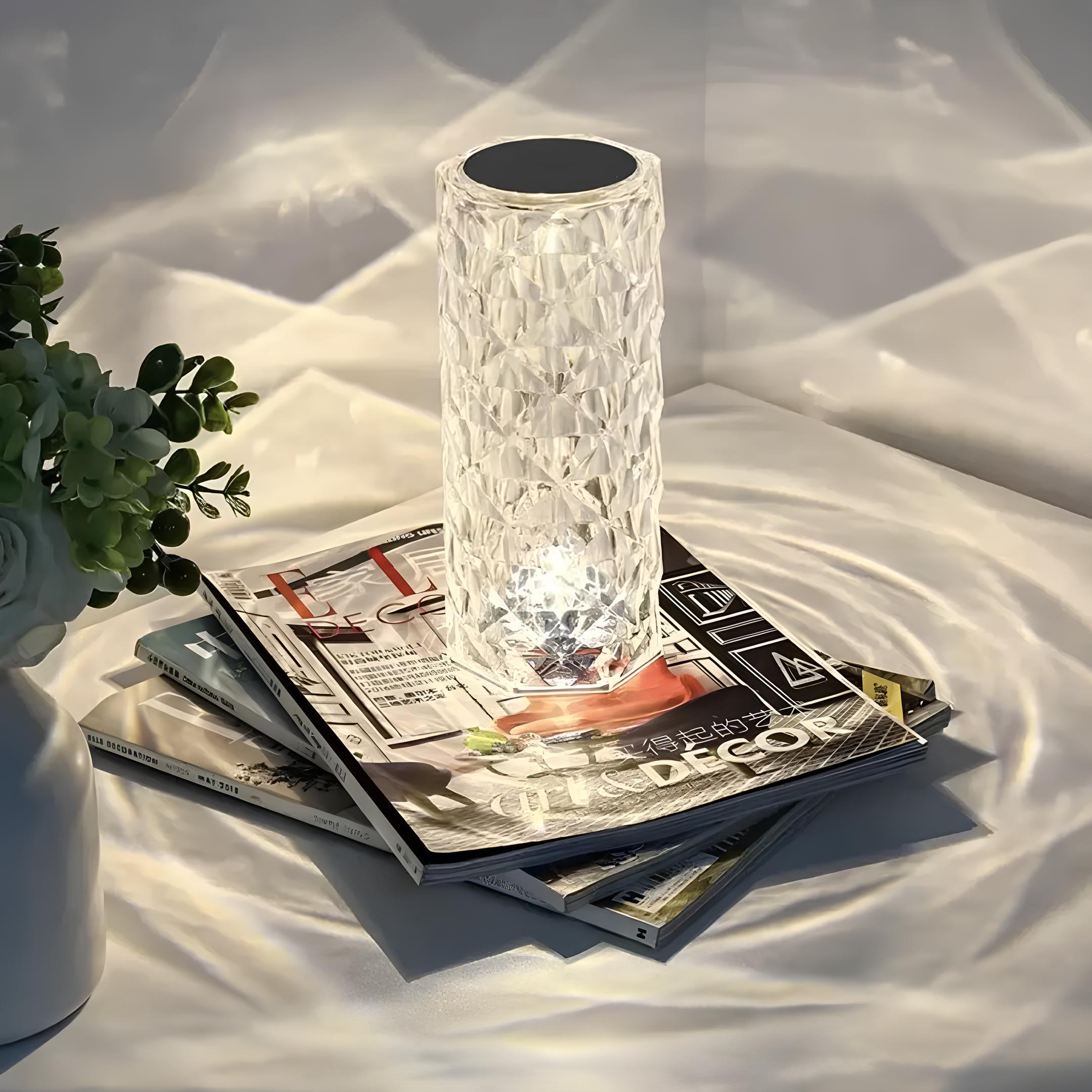 Clear glass lamp on top of a magazine with a white background