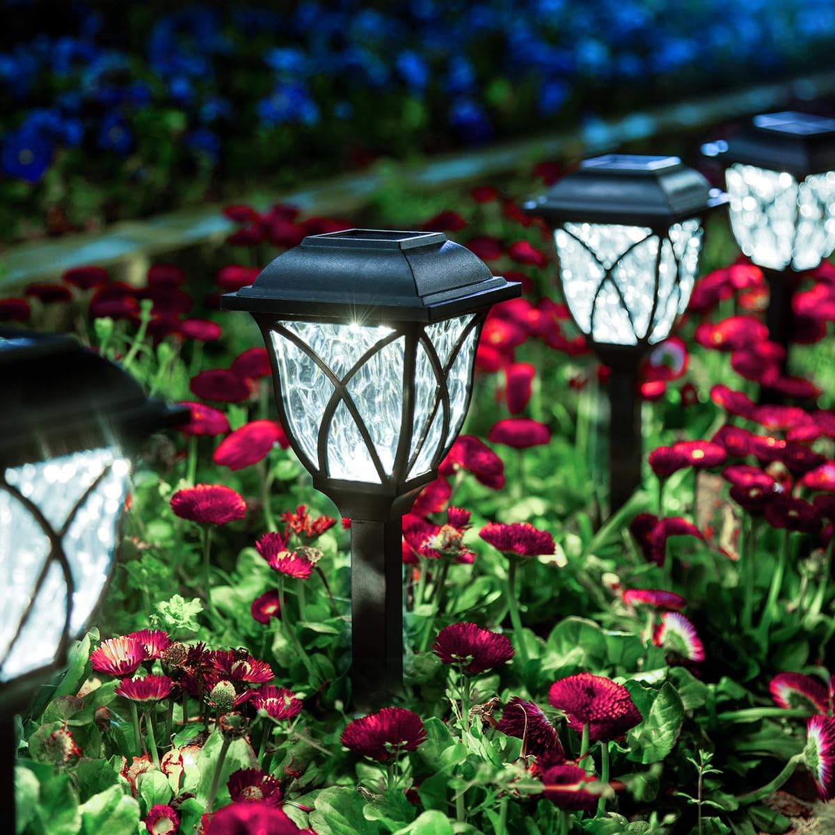 Solar garden lights in a flower bed with colorful flowers
