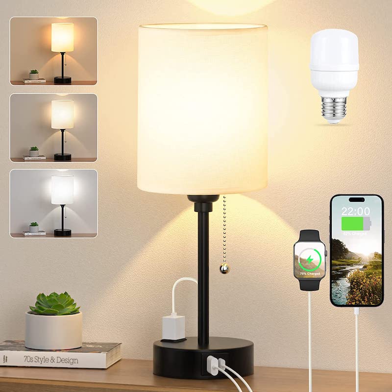 Table lamp with multiple outlets and a smartphone displaying time, set against a neutral wall.