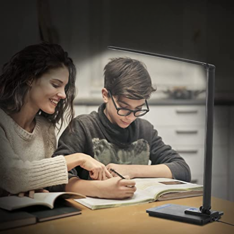 Woman and boy studying with a lamp on a table