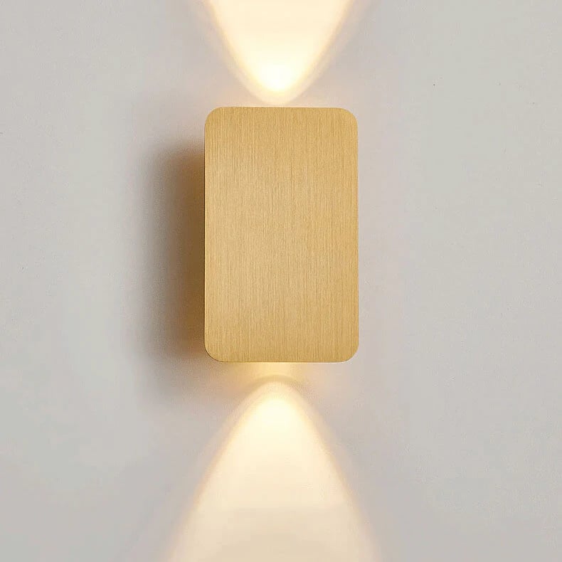 Gold square wall light fixture on a white wall